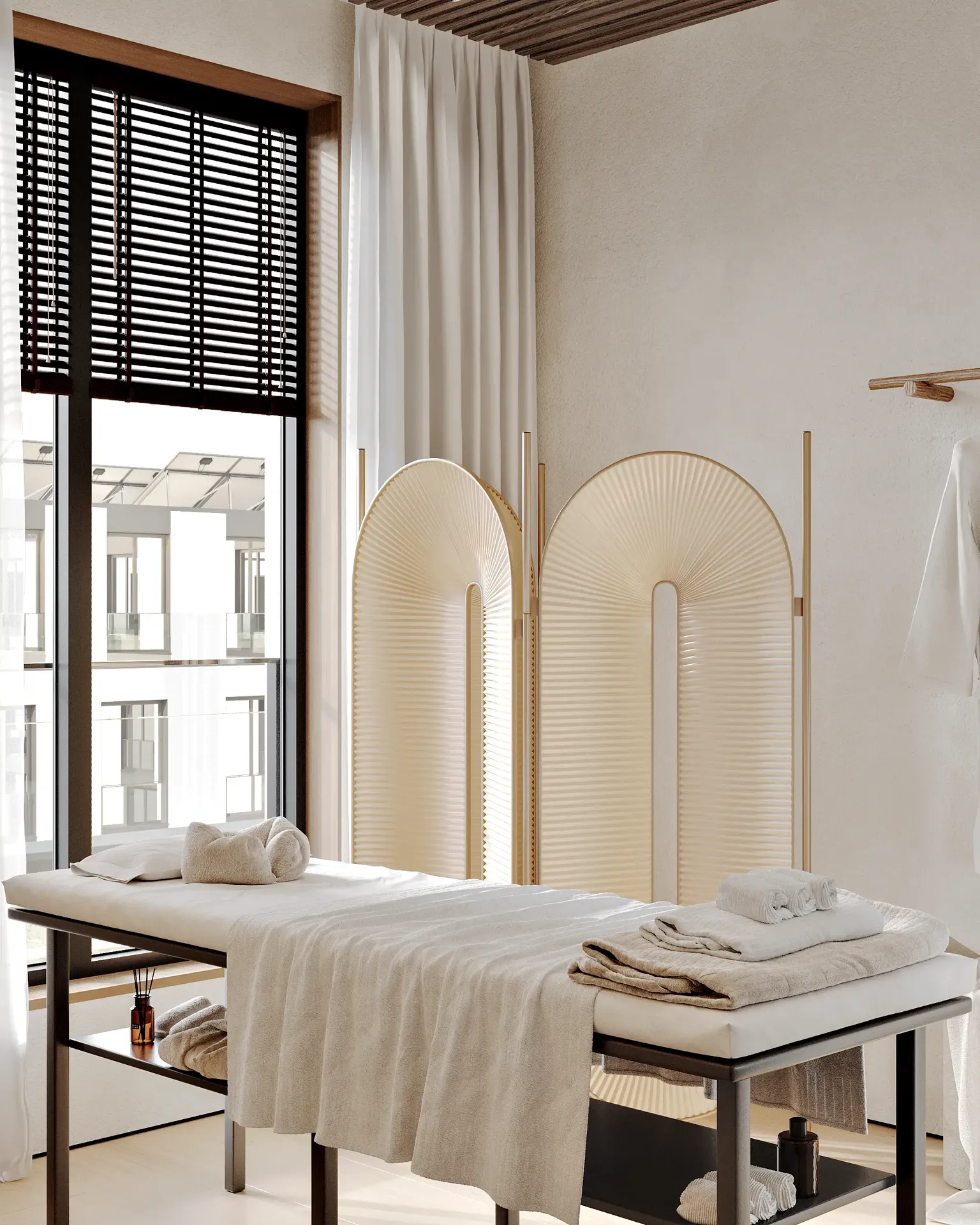 Calming treatment area featuring a massage bed and a privacy screen.