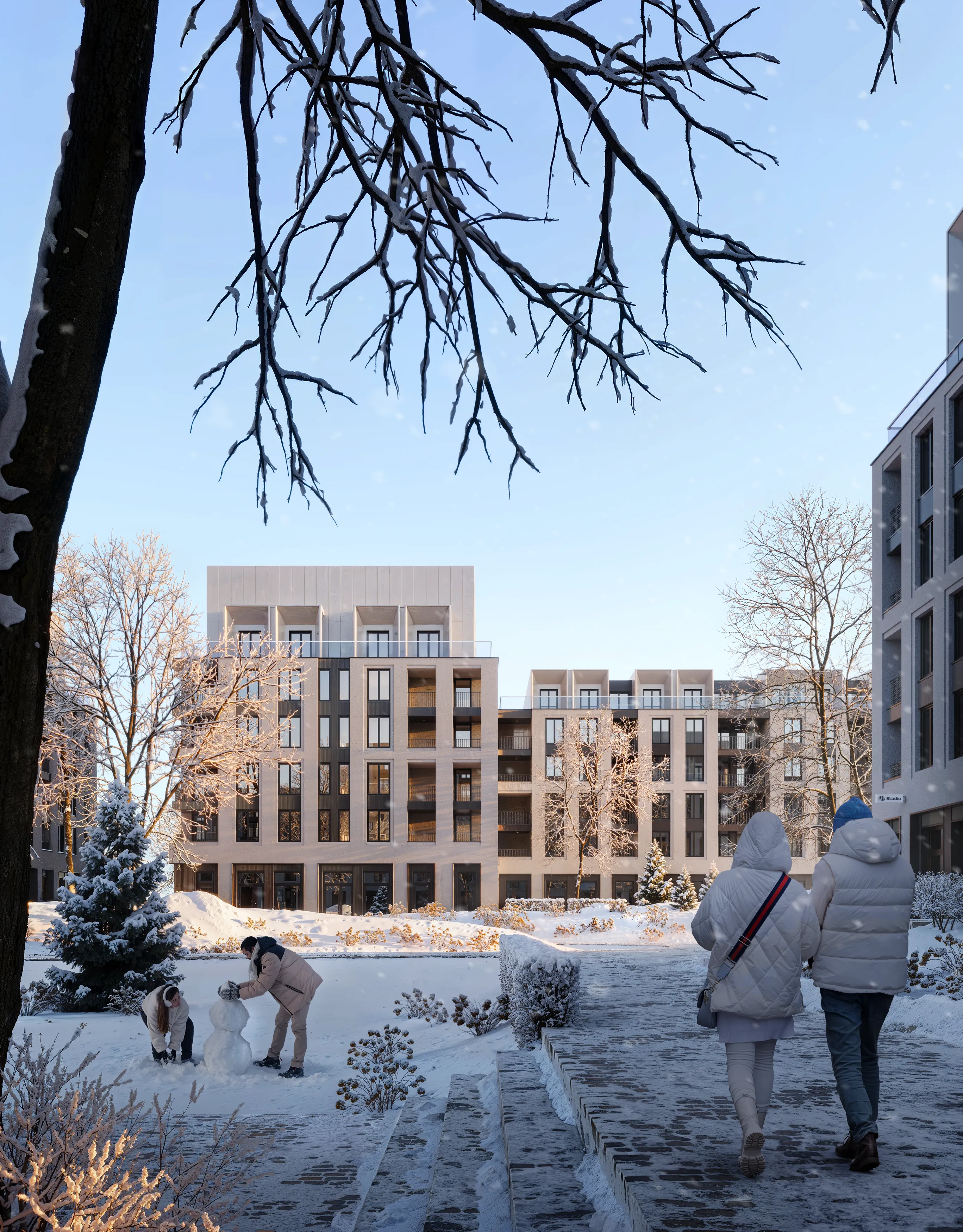 Two people walking on a snowy path in a modern residential area while two others build a snowman in the snow-covered courtyard.