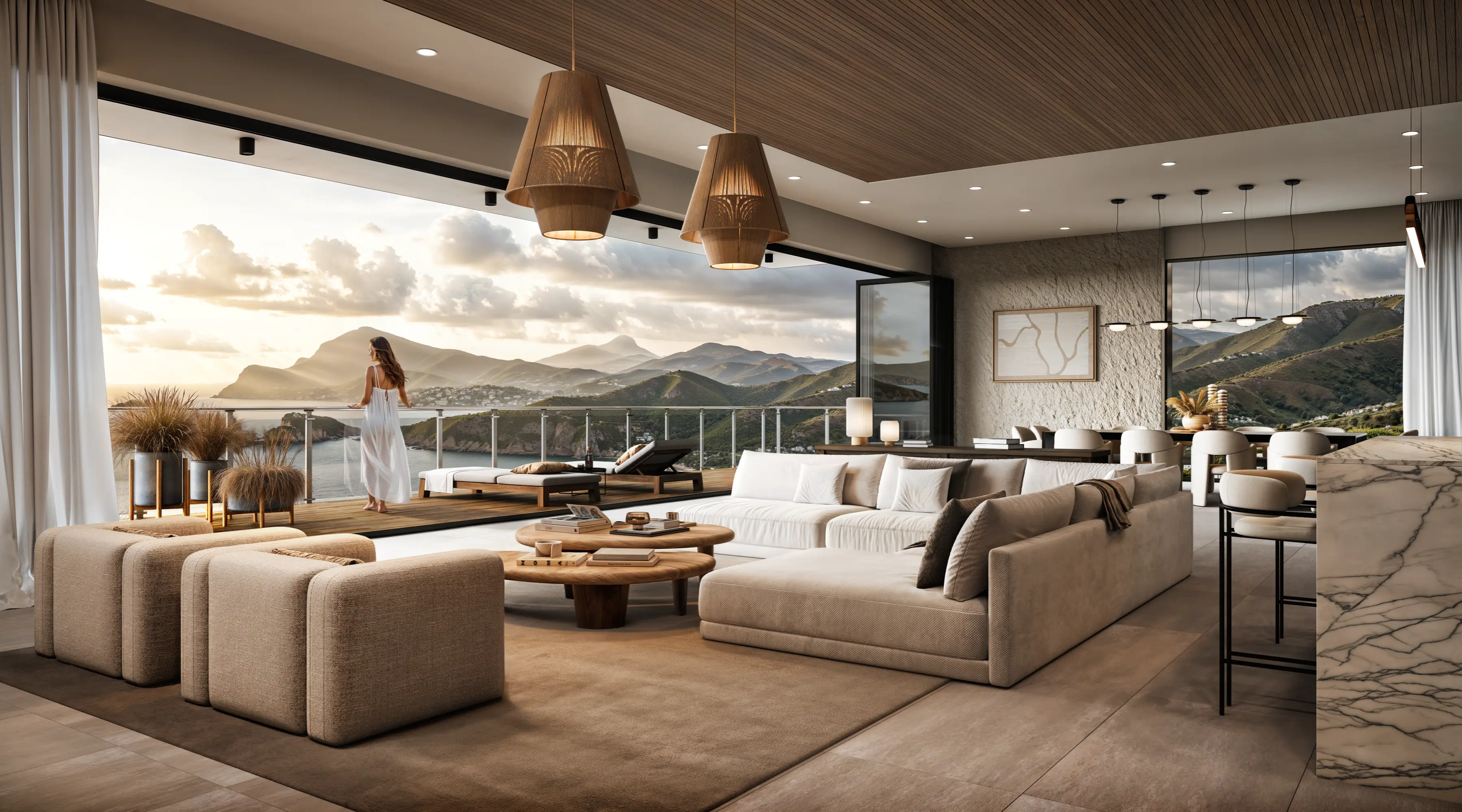 Modern living room with neutral-toned furniture and large sliding doors opening to a balcony overlooking mountains, ocean, and a woman standing at the railing.