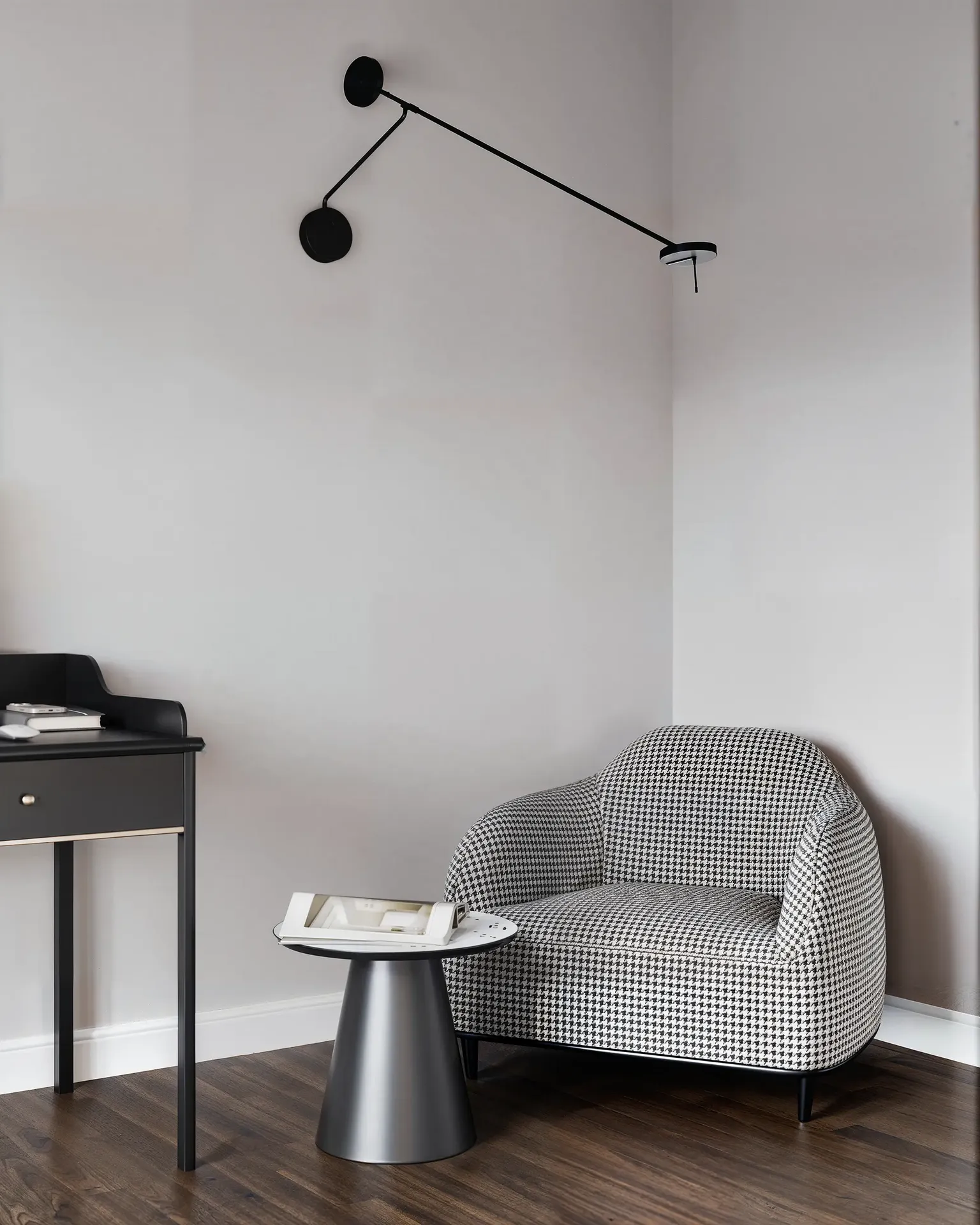 Coin lecture comprenant un fauteuil, une table d'appoint et une applique murale.
