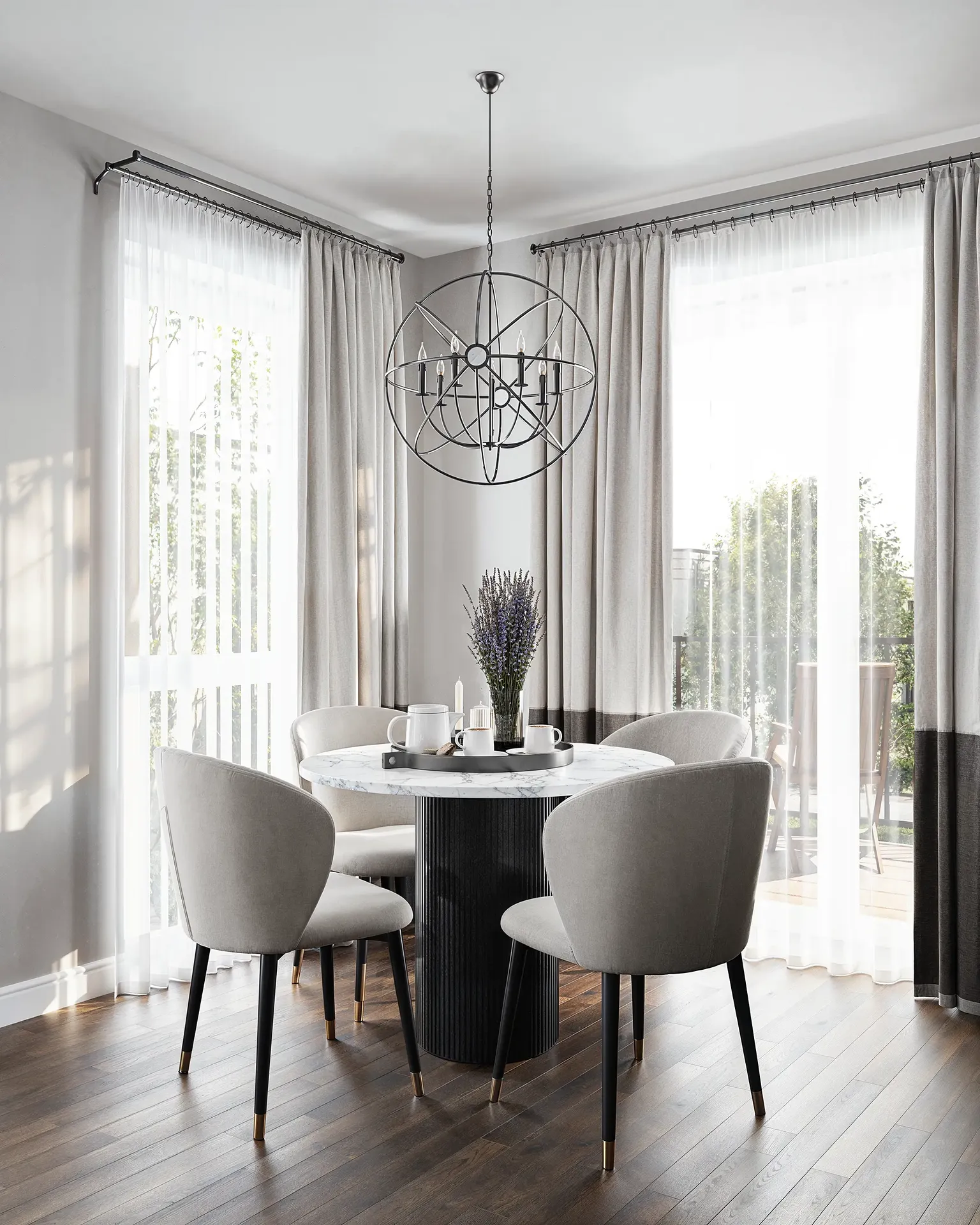 Coin repas lumineux avec table ronde en marbre et lustre orbe moderne.