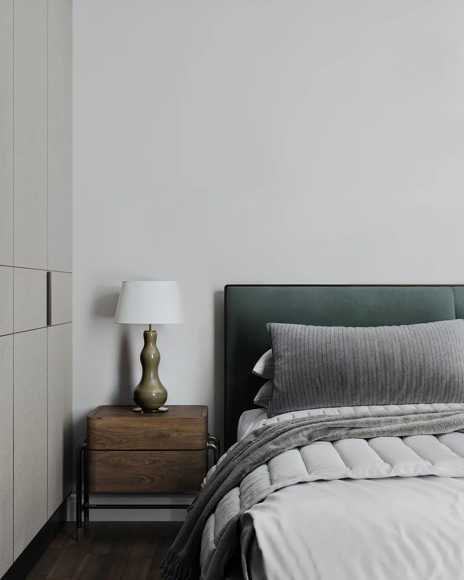 Gros plan sur une table de chevet, une lampe et une tête de lit.