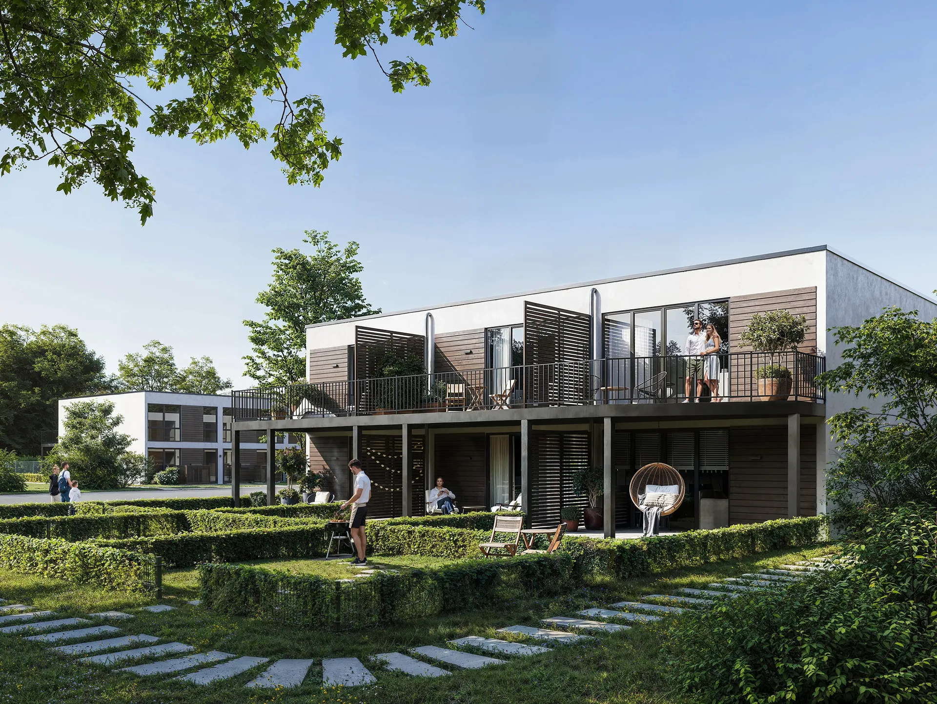 Vue ensoleillée d'une maison avec des résidents sur les balcons.