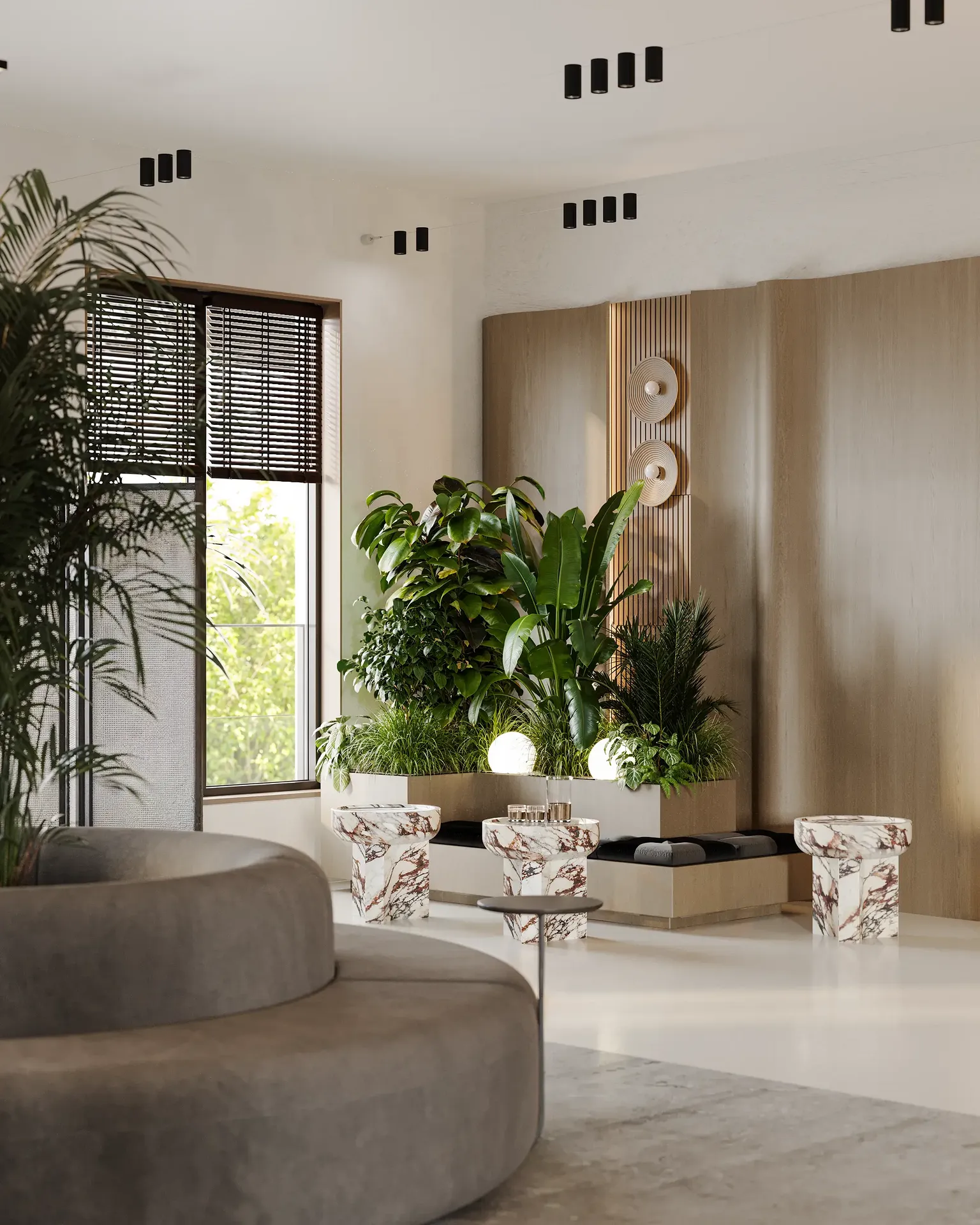 Sala de espera luminosa junto a una ventana con asientos, mesas de café y un gran arreglo floral.