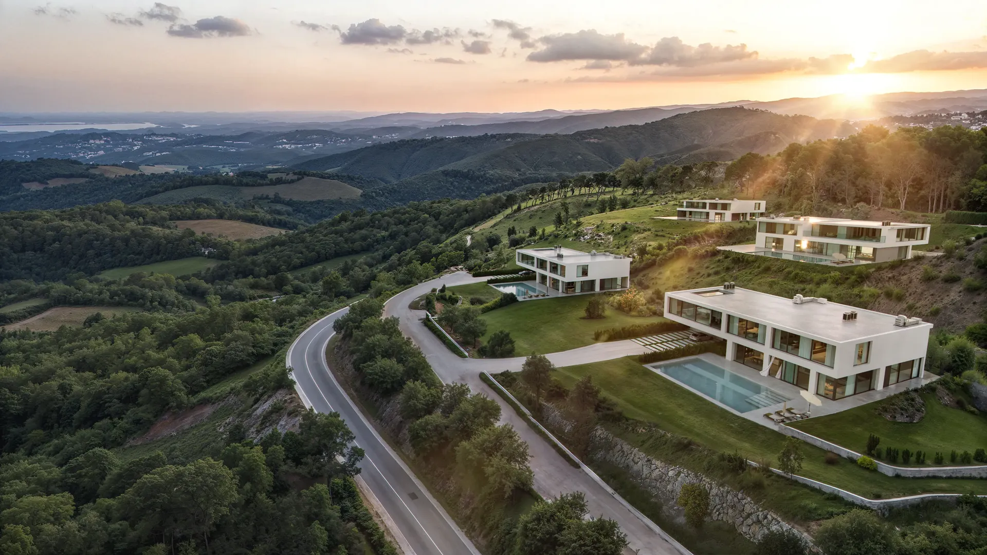 Complejo de villas de lujo en la ladera de una colina que brillan con la cálida luz de una puesta de sol.