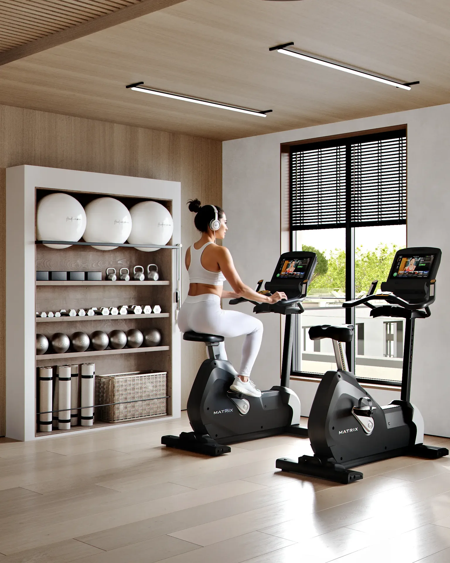 Modernes Fitnessstudio mit Blick auf die Cardio-Zone mit stationären Fahrrädern und Geräteregalen.