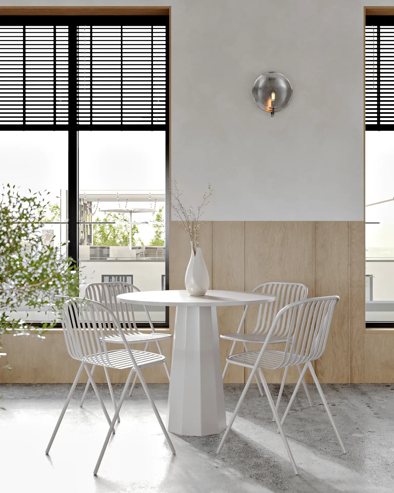 Mesa de comedor para cuatro personas iluminada por el sol, situada junto a un gran ventanal en una cafetería.