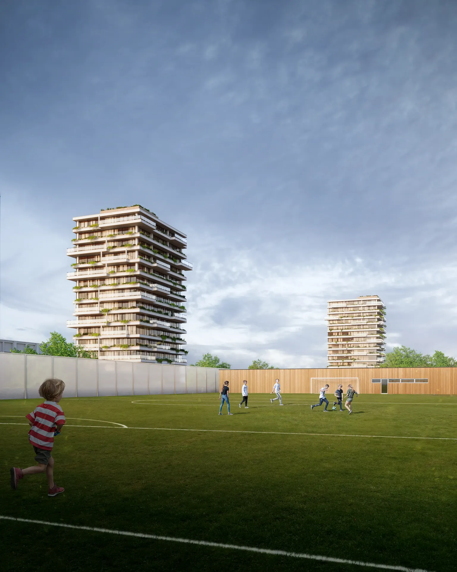 Des enfants jouent au football sur un terrain de sport communautaire moderne au sein du complexe résidentiel.