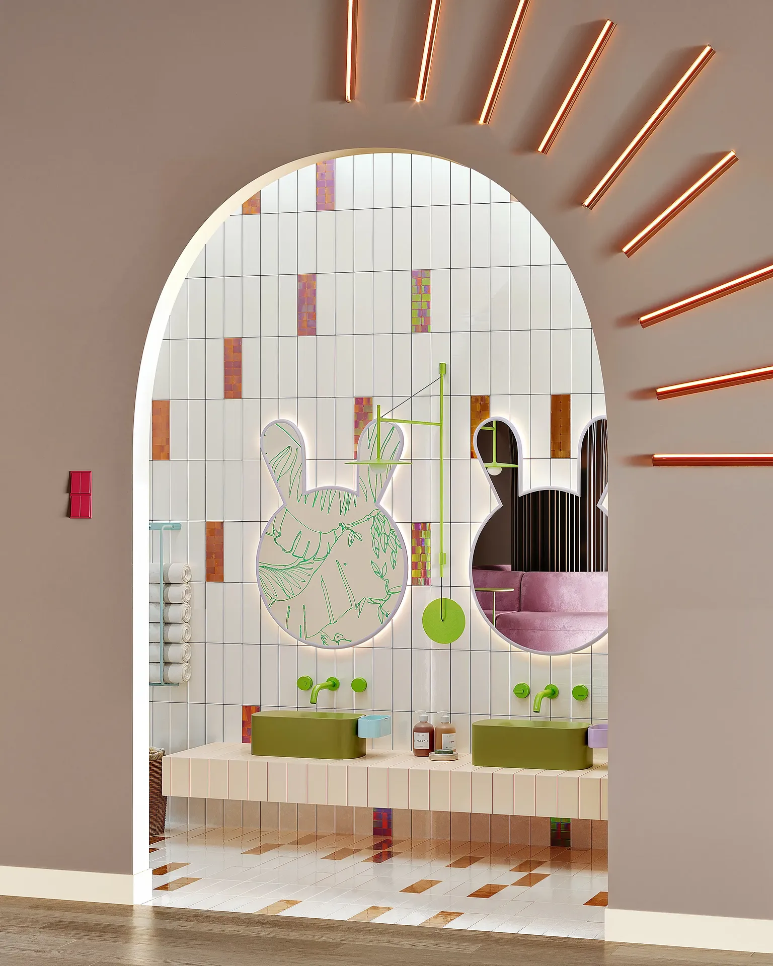 Toilettes pour enfants lumineuses avec lavabos bas et luminaires colorés au niveau de la station de lavage des mains.