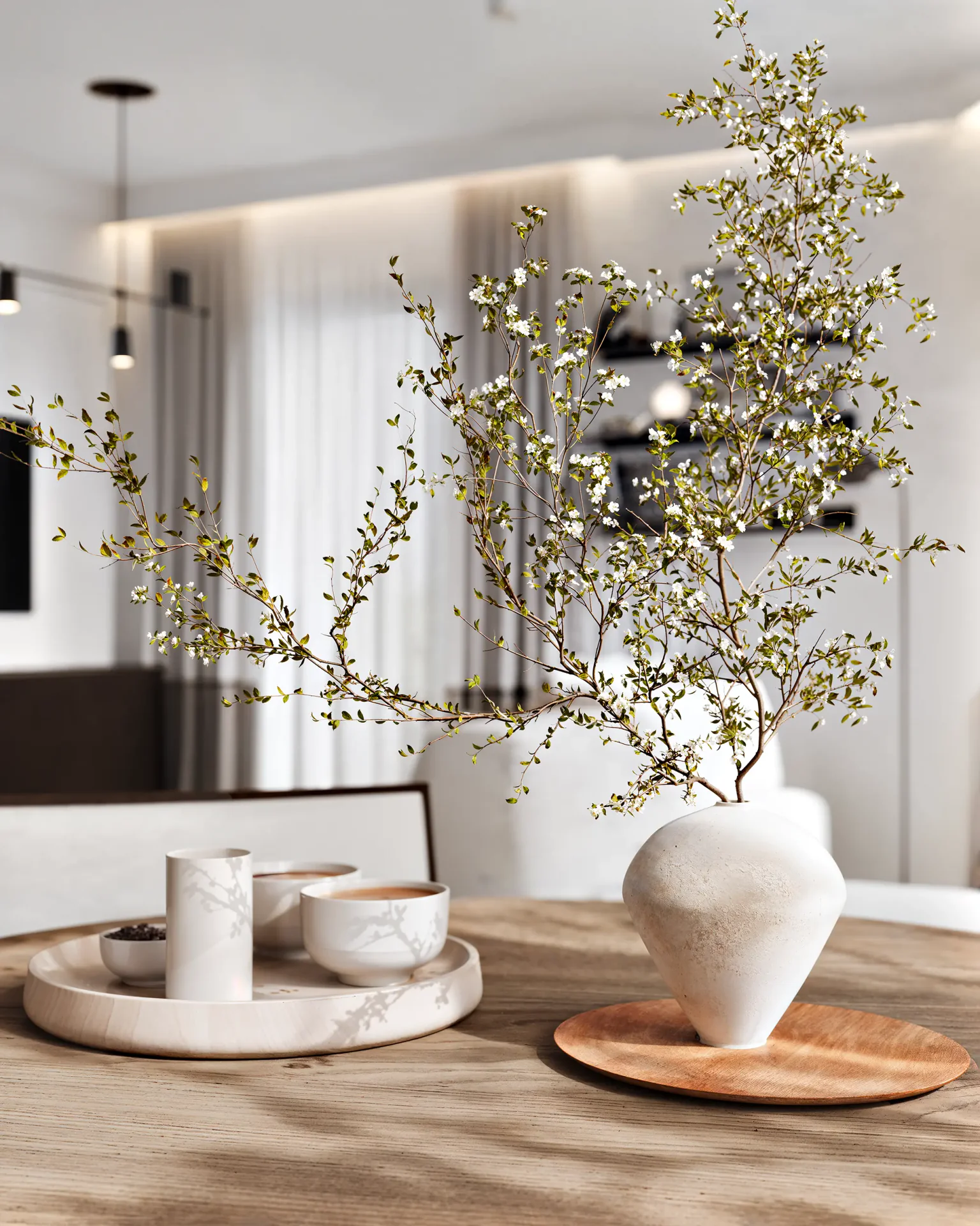 Close-up of an elegant tablescape on a dining table, featuring a modern vase and dishes.